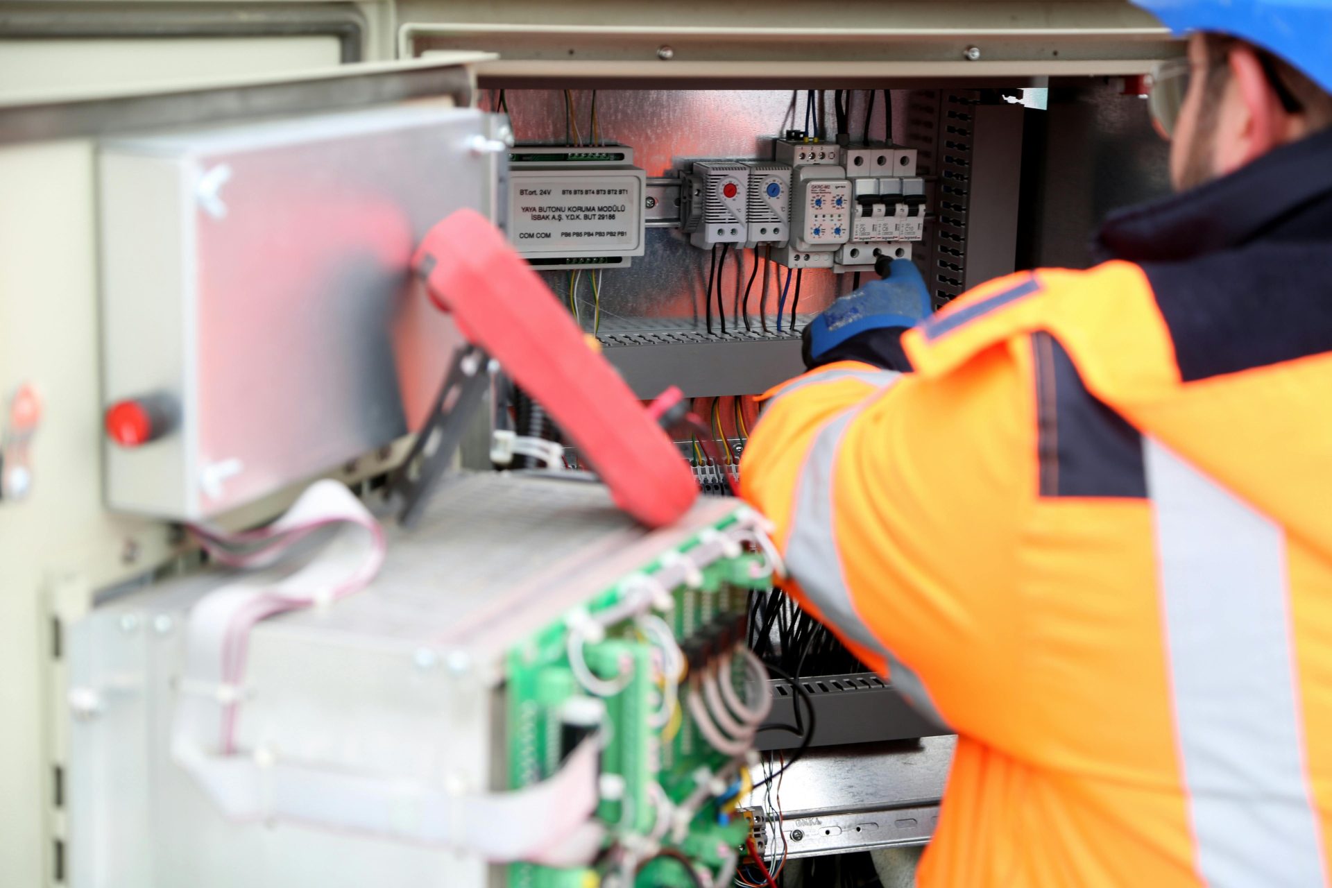 Ingeniero profesional inspeccionando placas de circuitos eléctricos industriales, garantizando el cumplimiento de las normas de seguridad.