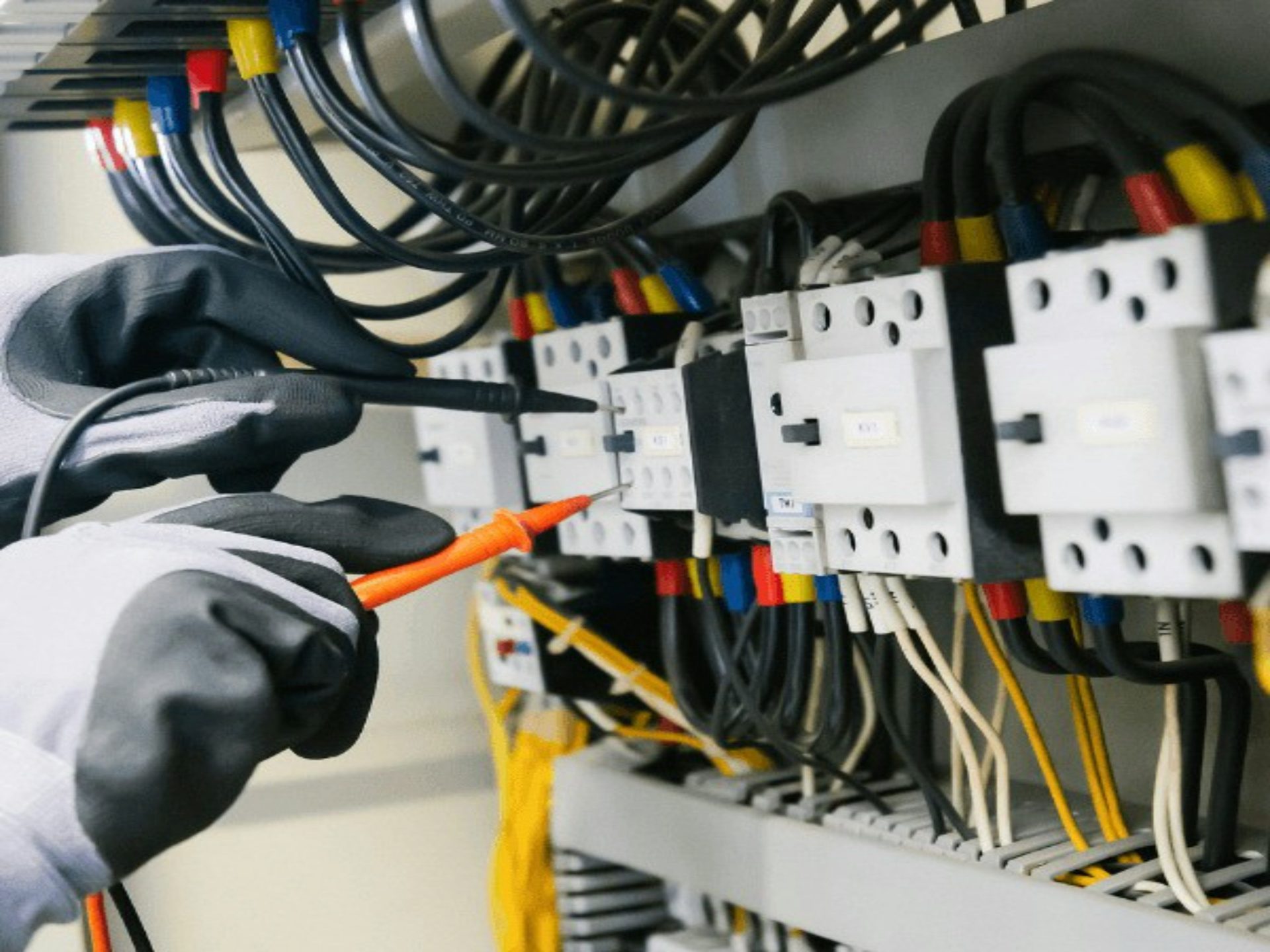 Electricista probando un panel eléctrico con un multímetro.